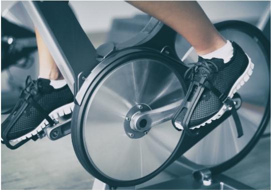 Piedi in movimento su cyclette, energia e determinazione in una sessione di allenamento.