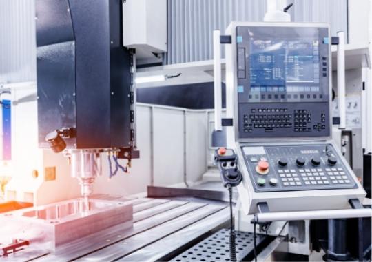 Macchina CNC moderna, luci fredde, precisione e innovazione in un ambiente industriale avanzato.