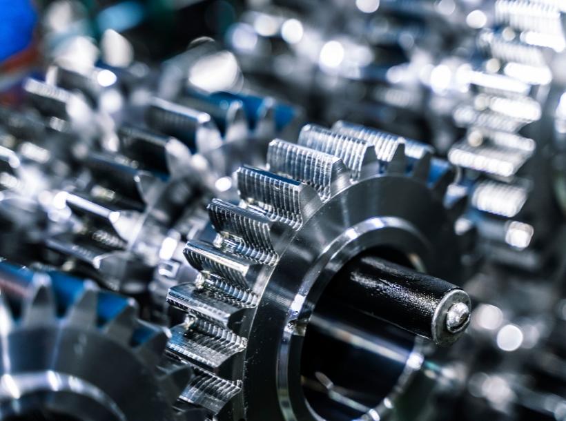 Ingranaggi metallici lucenti, complessi e affascinanti, simbolo di precisione e ingegneria avanzata.