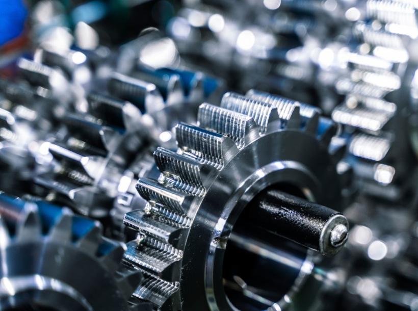 Ingranaggi metallici lucenti, intricati e precisi, evocano potenza e ingegneria avanzata.
